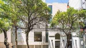 En modern byggnad med ett stort fönster, en dörr och en liten balkong.