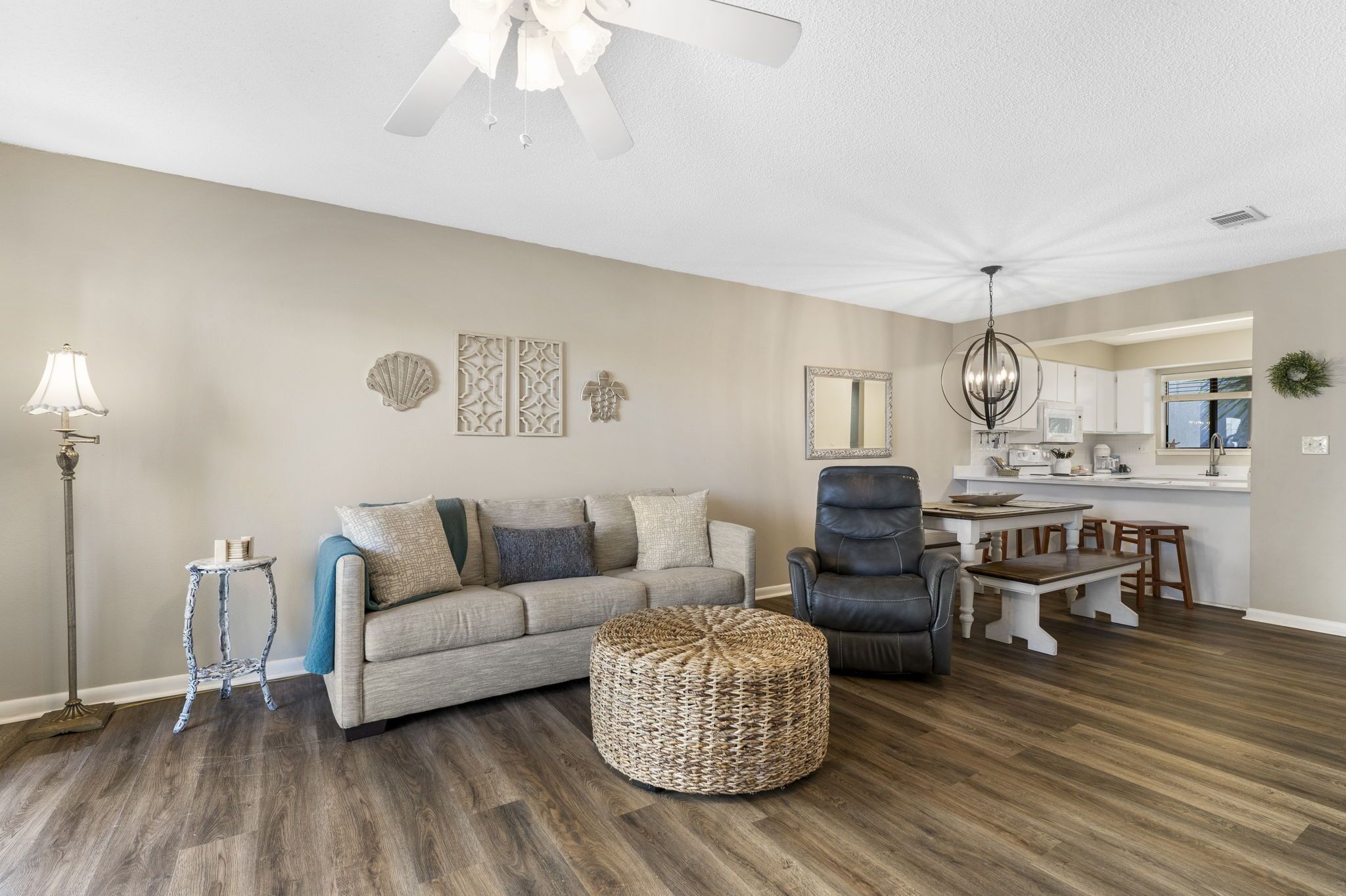 A living room with a sofa, ottoman, and a dining area with a table and chairs.