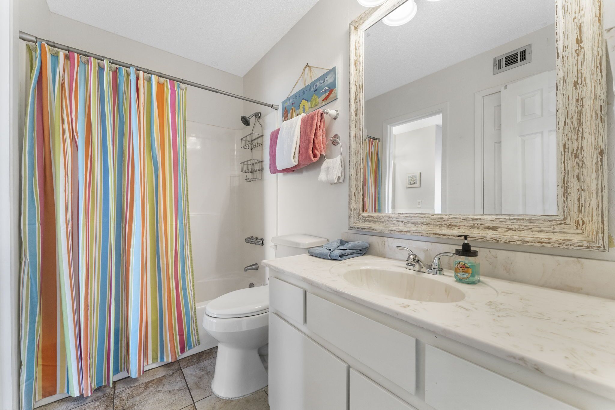 Un baño con ducha, inodoro, lavabo y espejo.