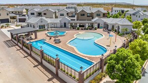 A residential area with a swimming pool, lounge chairs, and a covered patio. - The Sandlot - Sand Hollow & Zion - Entire Home with Private Pool (Hurricane)