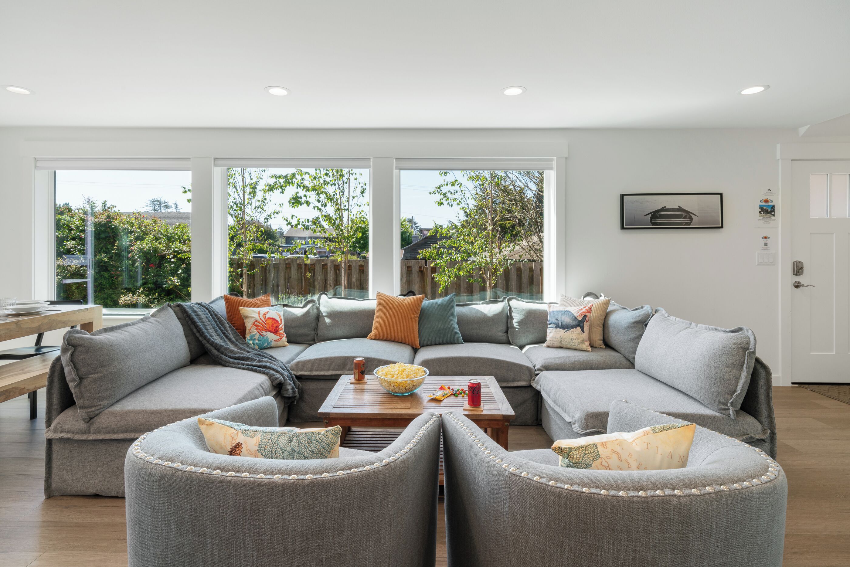 A modern living room with a sectional sofa, two armchairs, and a coffee table.