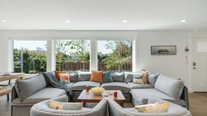 A modern living room with a sectional sofa, two armchairs, and a coffee table.