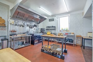 A modern kitchen with stainless steel appliances, a large window, and a variety of utensils and cookware. - Waterfall Country Escape (Neath)