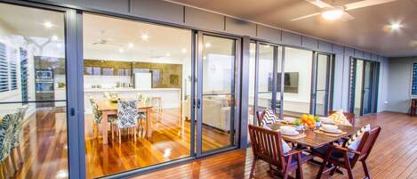 A modern interior with a dining area, kitchen, and sliding glass doors leading to a balcony.