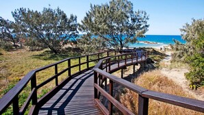 A wooden boardwalk leading to a beach with clear skies. - Drishti - Sunrise at 1770 (Agnes Water)