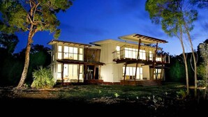 A two-story house with large windows, a balcony, and a well-maintained lawn. - Drishti - Sunrise at 1770 (Agnes Water)