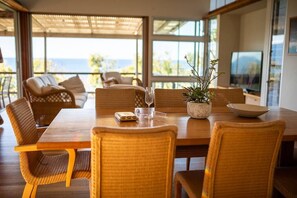 Enjoy meals in this dining area with a table for four, wicker chairs, and a potted plant.