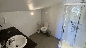 Un bagno con lavandino, wc e cabina doccia in vetro.