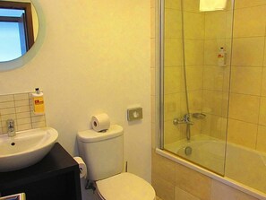 Bathroom features a sink, toilet, and glass-enclosed shower area.