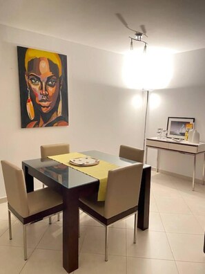 Enjoy meals with family and friends at this dining area, featuring a table for four and a comfortable seating arrangement.