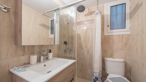 A modern bathroom with a glass-enclosed shower, a white sink, and a toilet. - Cozy Acropolis Studio by Cloudkeys (Athens)