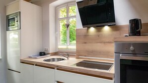 Eine moderne Küche mit integriertem Mikrowellenherd, einer Kaffeemaschine und einem Fenster mit Herzdeko.