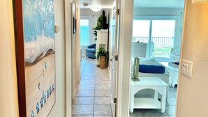 A hallway leading to a living area with a view of the outdoors. - Book Sailfish Sands Now! Oceanfront 3BR + Amazing Views & Special Deals (Cocoa Beach)