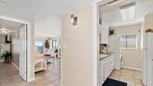 A spacious kitchen with white cabinets, a built-in oven, and a window with blinds. - Book Sailfish Sands Now! Oceanfront 3BR + Amazing Views & Special Deals (Cocoa Beach)
