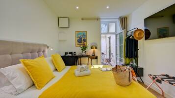 Une chambre d’hôtel équipée d’un lit, d’un bureau, d’une chaise, d’un porte-chapeau et d’une fenêtre.