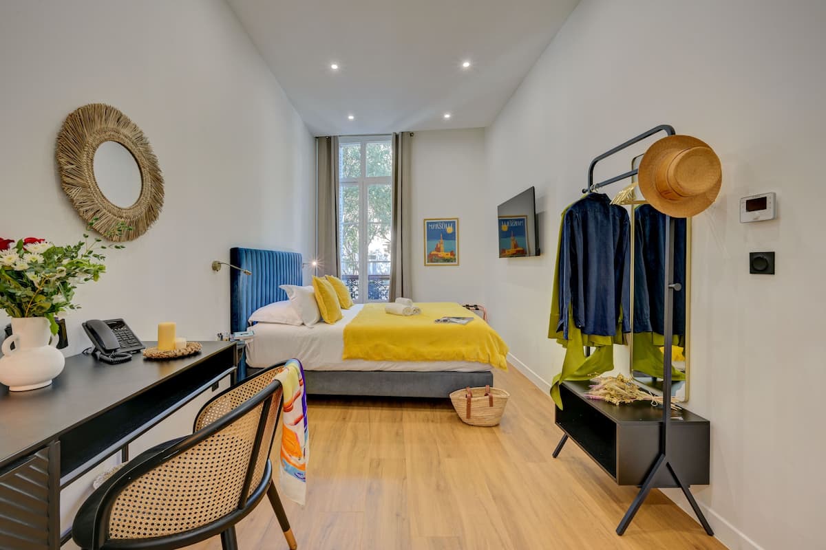 A modern bedroom with a bed, bedside table, and a clothing rack.