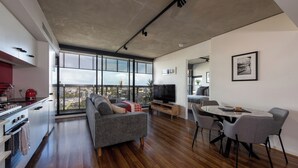 Un espacio habitable moderno con un ventanal grande, una zona de comedor y una cocina.