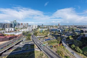 A cityscape with modern buildings, a highway, and a bridge.