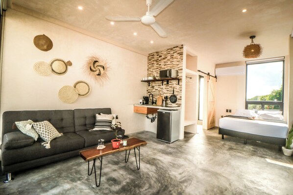 A modern living space with a sofa, coffee table, and a kitchenette area. - Villa Emilia Tulum downtown with pool (Tulum)