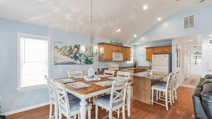 Una cocina amplia con comedor, muebles de madera y una lámpara de araña.