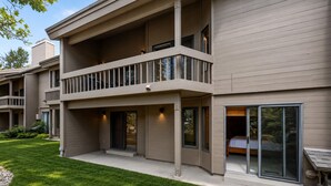 Un immeuble résidentiel à plusieurs étages, doté d’un balcon, de grandes fenêtres et d’une pelouse bien entretenue.