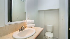 Eenvoudige tweepersoonskamer | Badkamer | Een douche, een regendouche, handdoeken, zeep