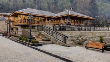 A hotel with a reception area, a balcony, and a stone wall.