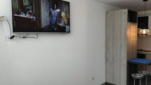 Ett modernt kök med en inbyggd spis, en diskho och en liten matplats med ett blått bord.