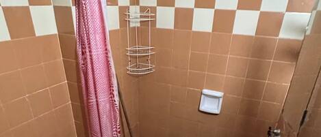 Un baño pequeño con dos inodoros, un lavabo, un bidé y una cortina de ducha.