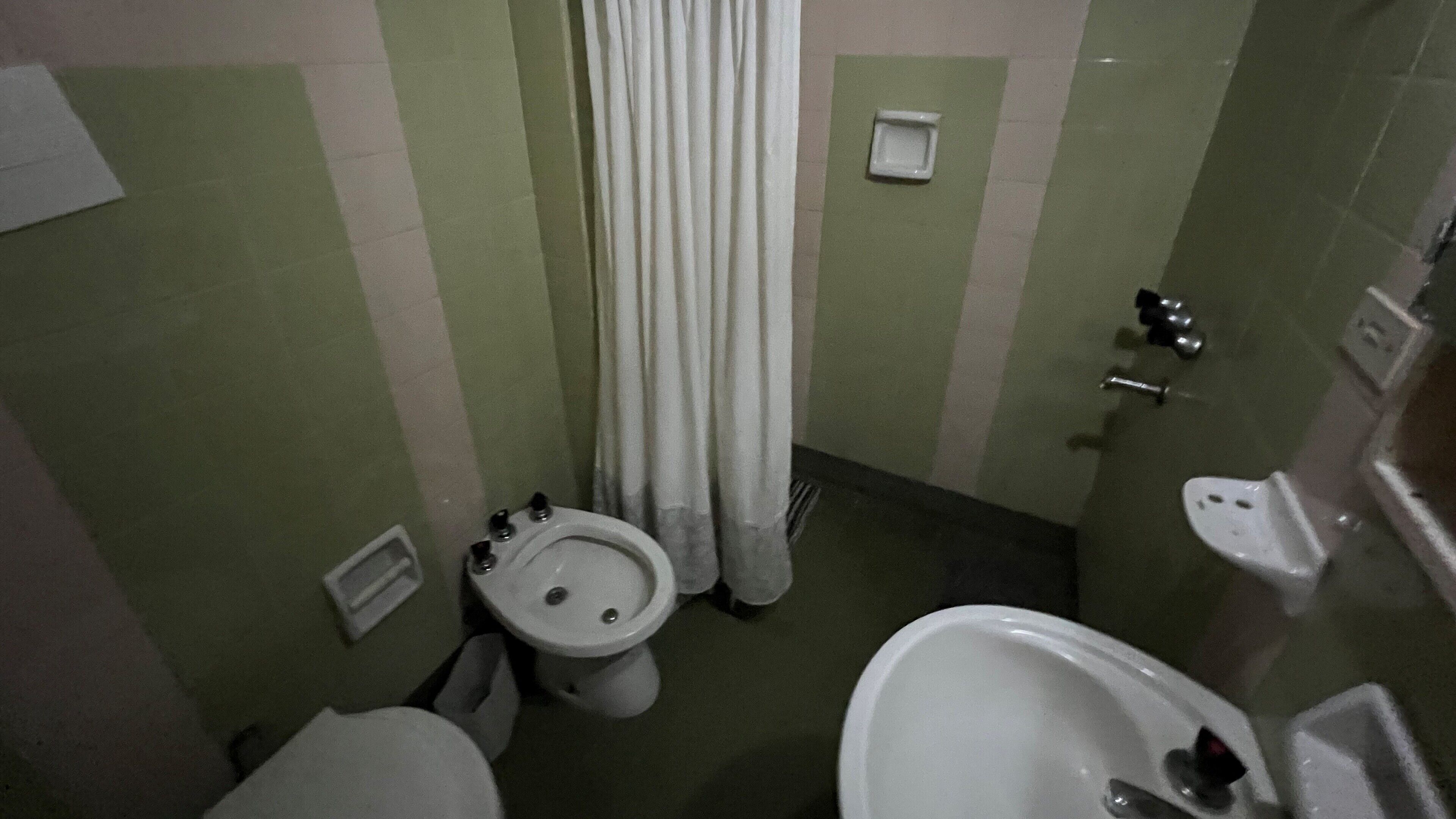 Une petite salle de bain avec des toilettes, un bidet et un lavabo.