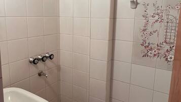 Een badkamer met een douche, een wastafel en een toilet.