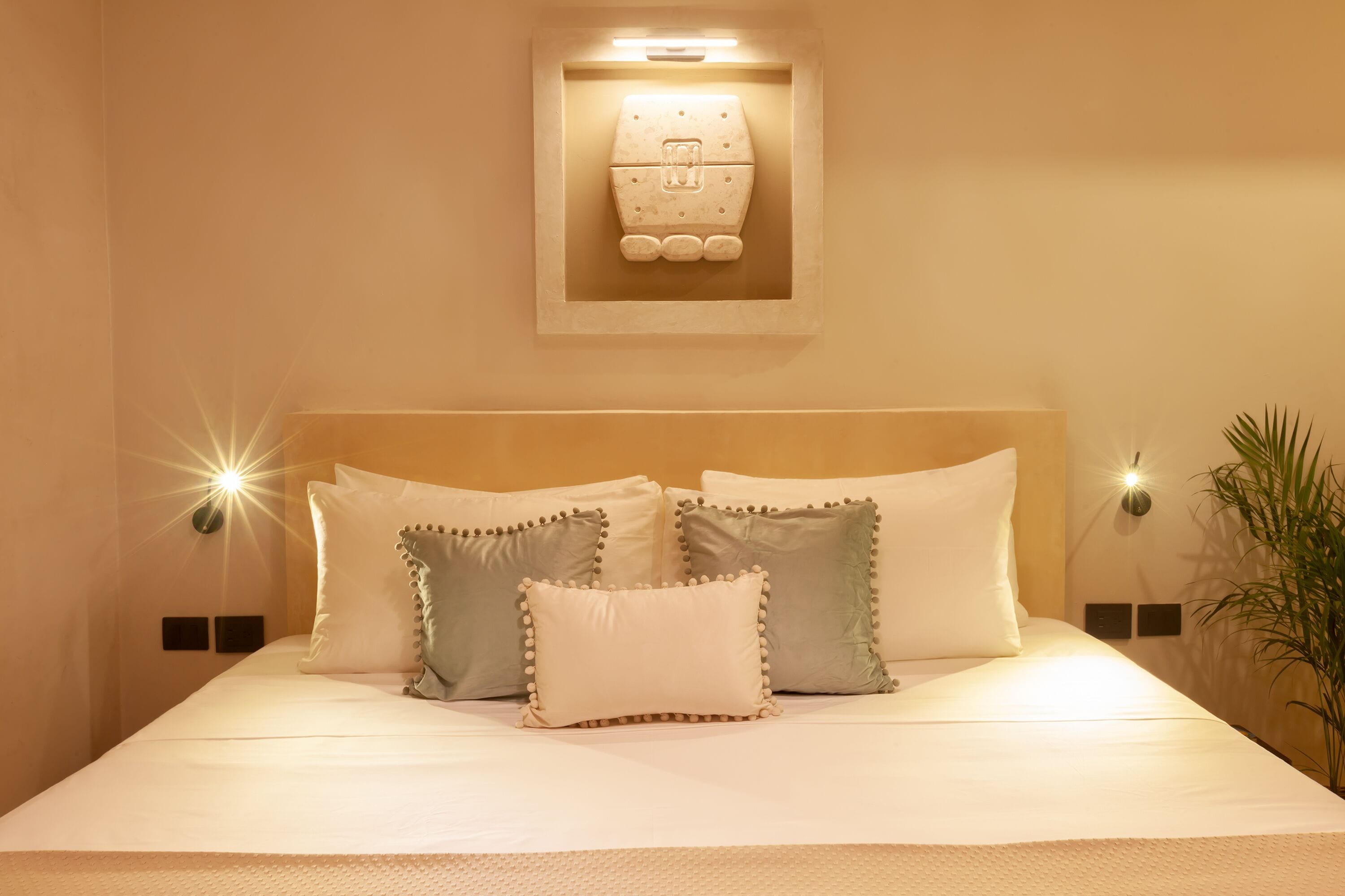 A neatly made bed with multiple pillows and a headboard.
