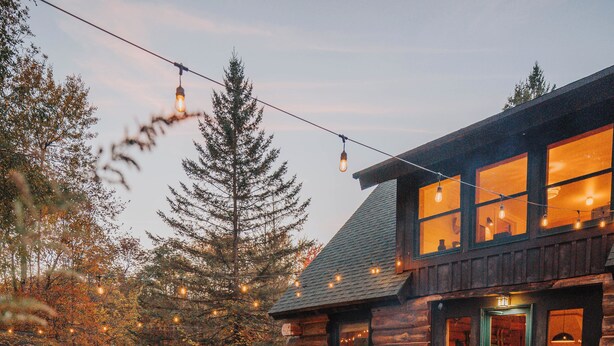 Ein rustikales Holzhaus mit Feuerstelle und Sitzbereich im Freien.