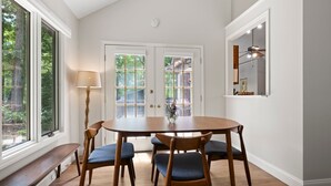 Et spiseområde med et træbord, fire stole, en bænk og en lampe.