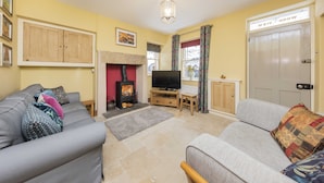 A living room with two sofas, a TV, a fireplace, and a door labeled "WOD AVIEW."