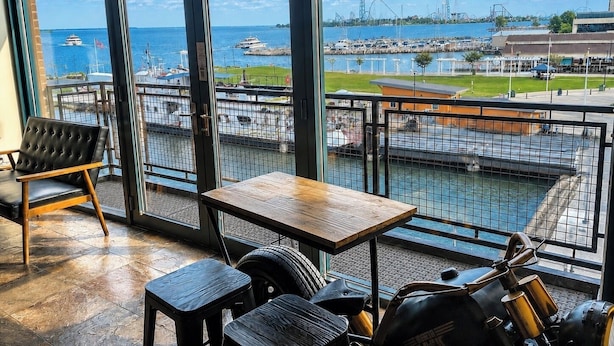 Ein Zimmer mit großem Fenster mit Blick auf eine Marina, wo Boote und eine Achterbahn zu sehen sind.