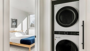 A modern bedroom with a bed, a washing machine, and a dryer. - Downtown Ballard View Home Walk to Bars & Shops (Seattle)