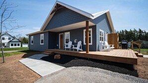 Una casa moderna con un portico coperto, un patio e posti a sedere all'aperto.