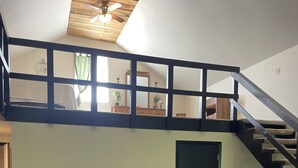 A loft-style living space with a sofa, coffee table, and staircase. - Beautiful loft cabin!  (Baxter)