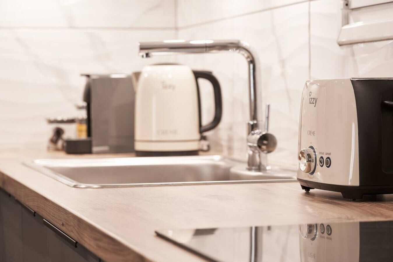 Une cuisine moderne équipée d’un évier, d’une machine à café et d’un grille-pain.