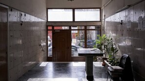 A hallway with lockers, a wooden door, a table with a plant, and a chair. - Fix  · Fix 2bd apartment with Parthenon view (Athina)