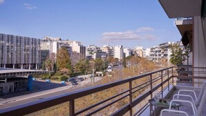 A balcony with a view of a cityscape, including modern buildings and a road. - Fix  · Fix 2bd apartment with Parthenon view (Athina)