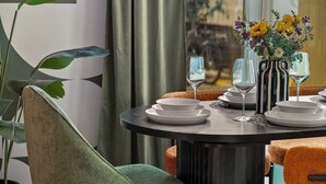 Een eettafel gedekt met borden, glazen en een vaas met bloemen.