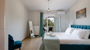 A bedroom with a bed, a chair, a table, and a window. - Villa Hercules | Refreshing Pool & Hydromassage (Rethymno)
