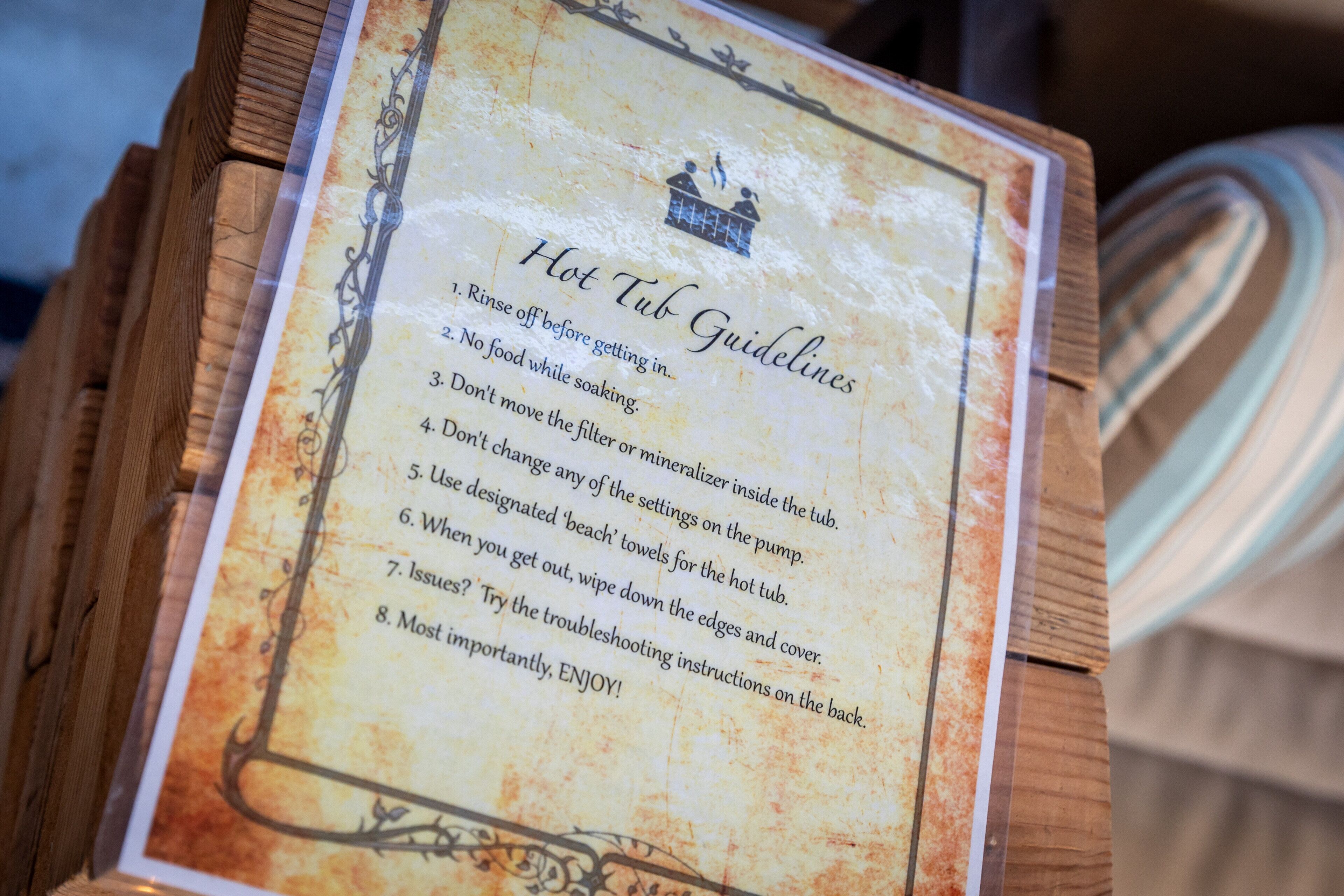 A wooden box with a sign listing hot tub guidelines.