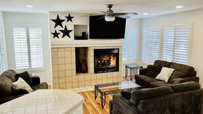 TV connectée, cheminée, lecteur de DVD, livres