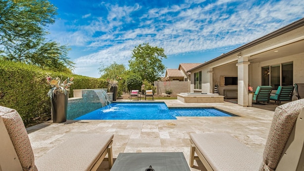 Un jardin avec une piscine, des chaises longues et un espace patio.