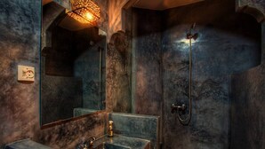 A bathroom with a large mirror, a sink, and a shower.