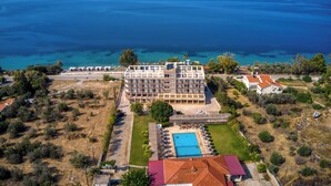An aerial view of a hotel with a swimming pool, surrounded by greenery and a view of the sea. - Black and White Boho Resort (Xylokastro-Evrostina)