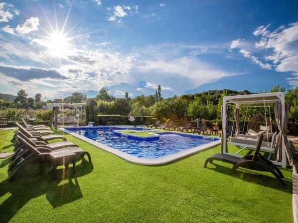 Relax by the pool surrounded by lounge chairs and a shaded pergola.
